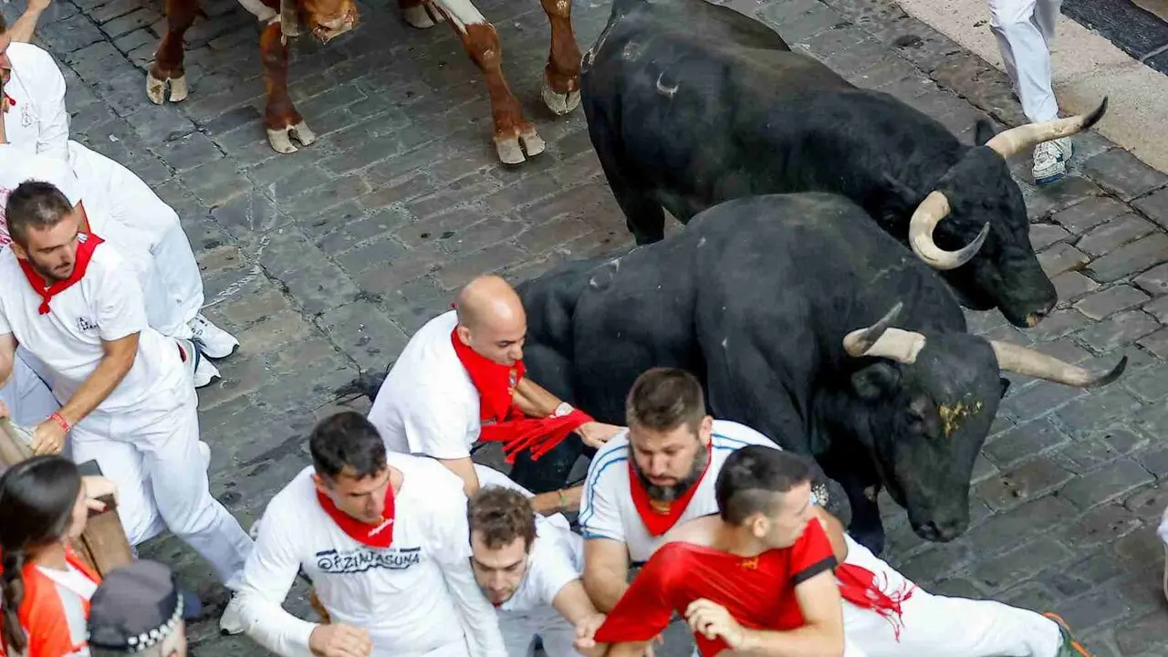 Un toro de la ganader&iacute;a extreme&ntilde;a de Jandilla embiste a varios mozos a su entrada en la calle Mercaderes durante el &uacute;ltimo encierro de los Sanfermines 2026. EFE / VILLAR L&Oacute;PEZ