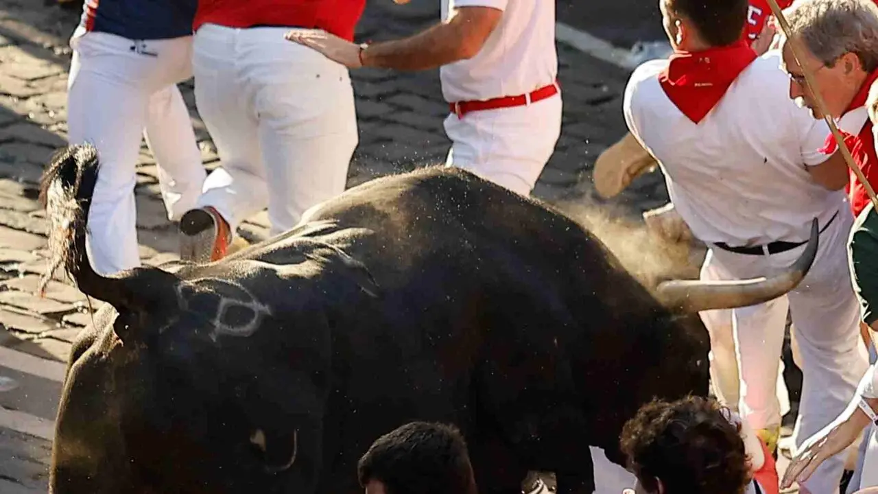 Un toro de la ganader&iacute;a extreme&ntilde;a de Jandilla embiste a varios mozos al principio de la calle Mercaderes, durante el &uacute;ltimo encierro de los Sanfermines 2026, este martes en Pamplona. EFE/Villar L&oacute;pez