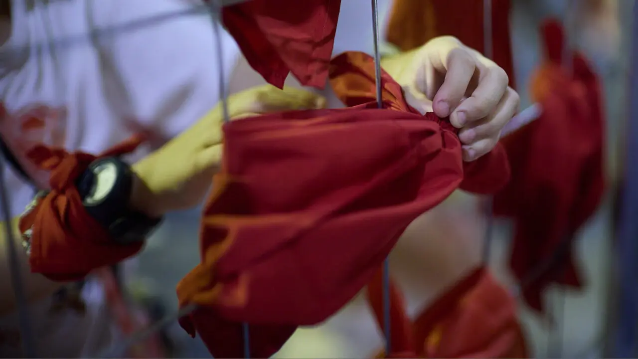 Cientos de personas depositan sus velas y pa&ntilde;uelos frente a la Iglesia de San Lorenzo momentos despu&eacute;s del Pobre de m&iacute; con el que finalizan los nueve d&iacute;as de las Fiestas de San Ferm&iacute;n 2026. I&Ntilde;IGO ALZUGARAY