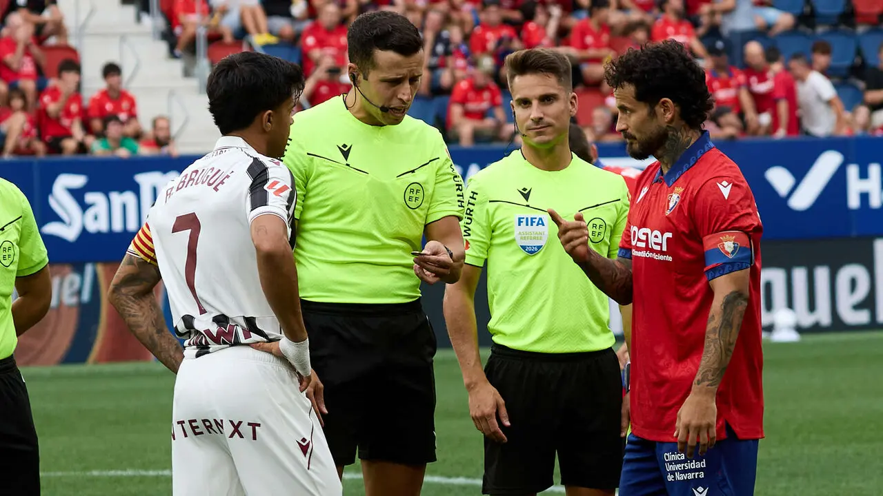 Roger Brugu&eacute; (7. Levante UD), V&iacute;ctor Garc&iacute;a Verdura (&aacute;rbitro del partido) y Rub&eacute;n Garc&iacute;a (14. CA Osasuna) durante el partido de La Liga EA Sports entre CA Osasuna y Levante UD disputado en el estadio de El Sadar en Pamplona. I&Ntilde;IGO ALZUGARAY