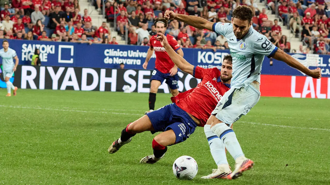 Andr&eacute;s Garc&iacute;a (21. GET) (Izda) remata a porter&iacute;a ante la oposici&oacute;n de Iker Mu&ntilde;oz (8. OSA) (Dcha) durante el partido de LaLiga EA Sports entre CA Osasuna y Getafe CF disputado en el estadio de El Sadar en Pamplona. I&Ntilde;IGO ALZUGARAY