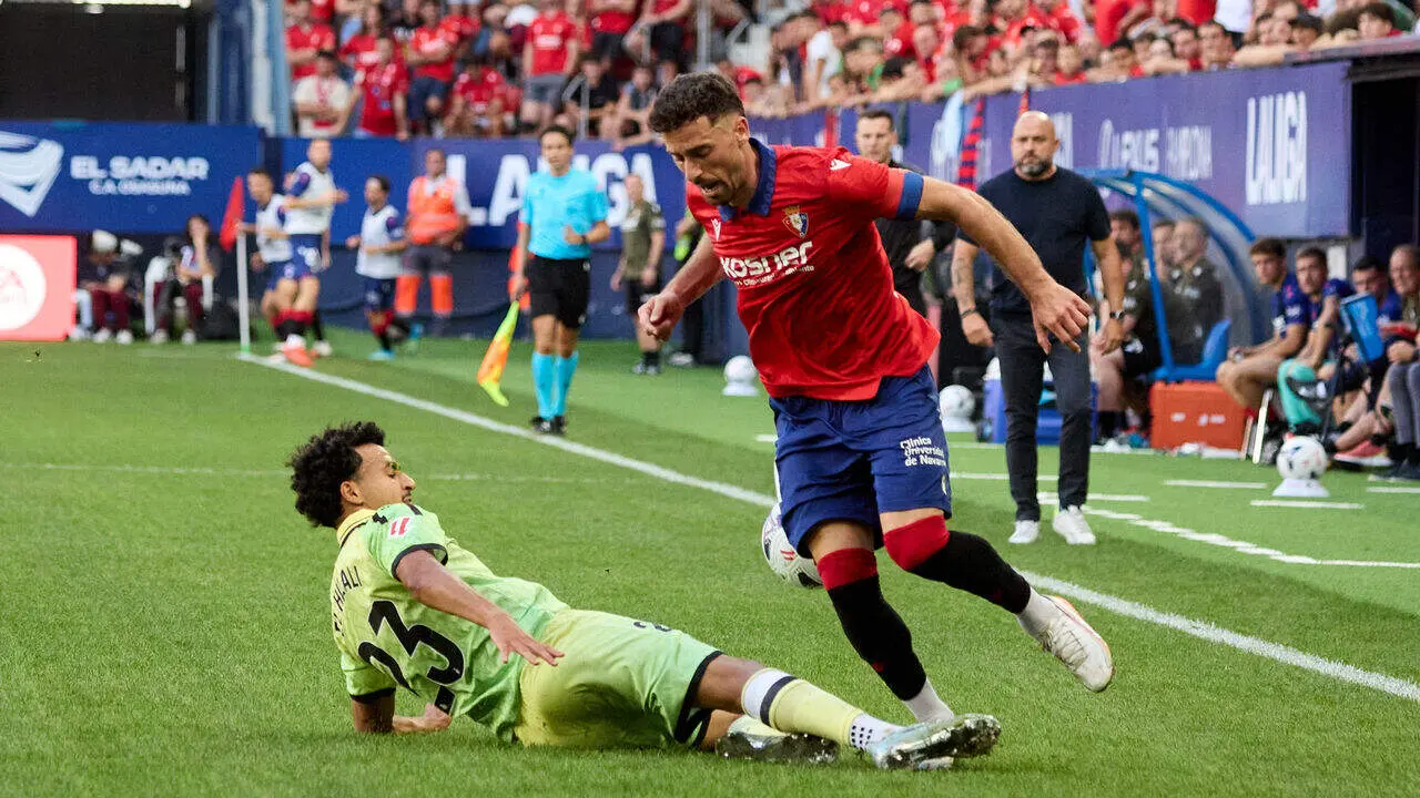 Omar El Hilali (23. ESP) (Izda) realiza una entrada a Kike Barja (11. OSA) (Dcha) durante el partido de LaLiga EA Sports entre CA Osasuna y RCD Espanyol disputado en el estadio de El Sadar en Pamplona. I&Ntilde;IGO ALZUGARAY