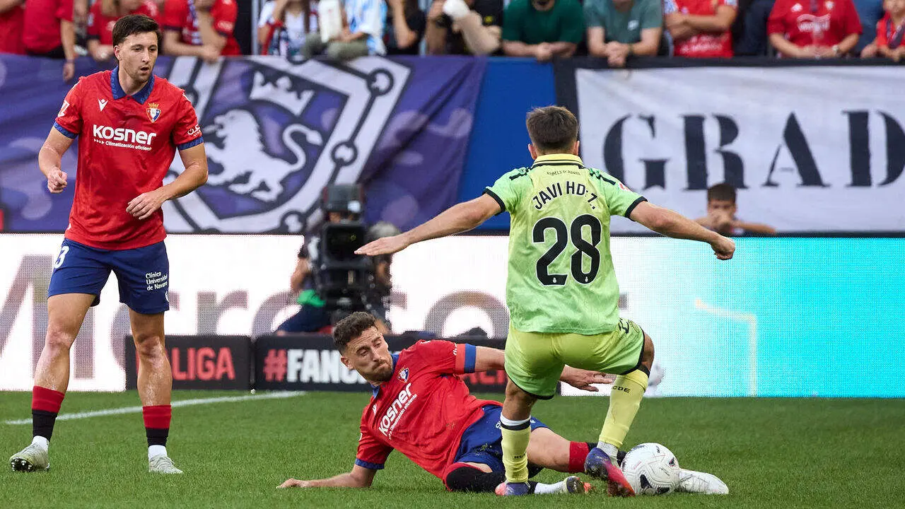 Kike Barja (11. OSA) (Izda) realiza una entrada a Javi Hern&aacute;ndez (28. ESP) (Dcha) durante el partido de LaLiga EA Sports entre CA Osasuna y RCD Espanyol disputado en el estadio de El Sadar en Pamplona. En la imagen tambi&eacute;n aparece Abel Bretones (23. OSA). I&Ntilde;IGO ALZUGARAY