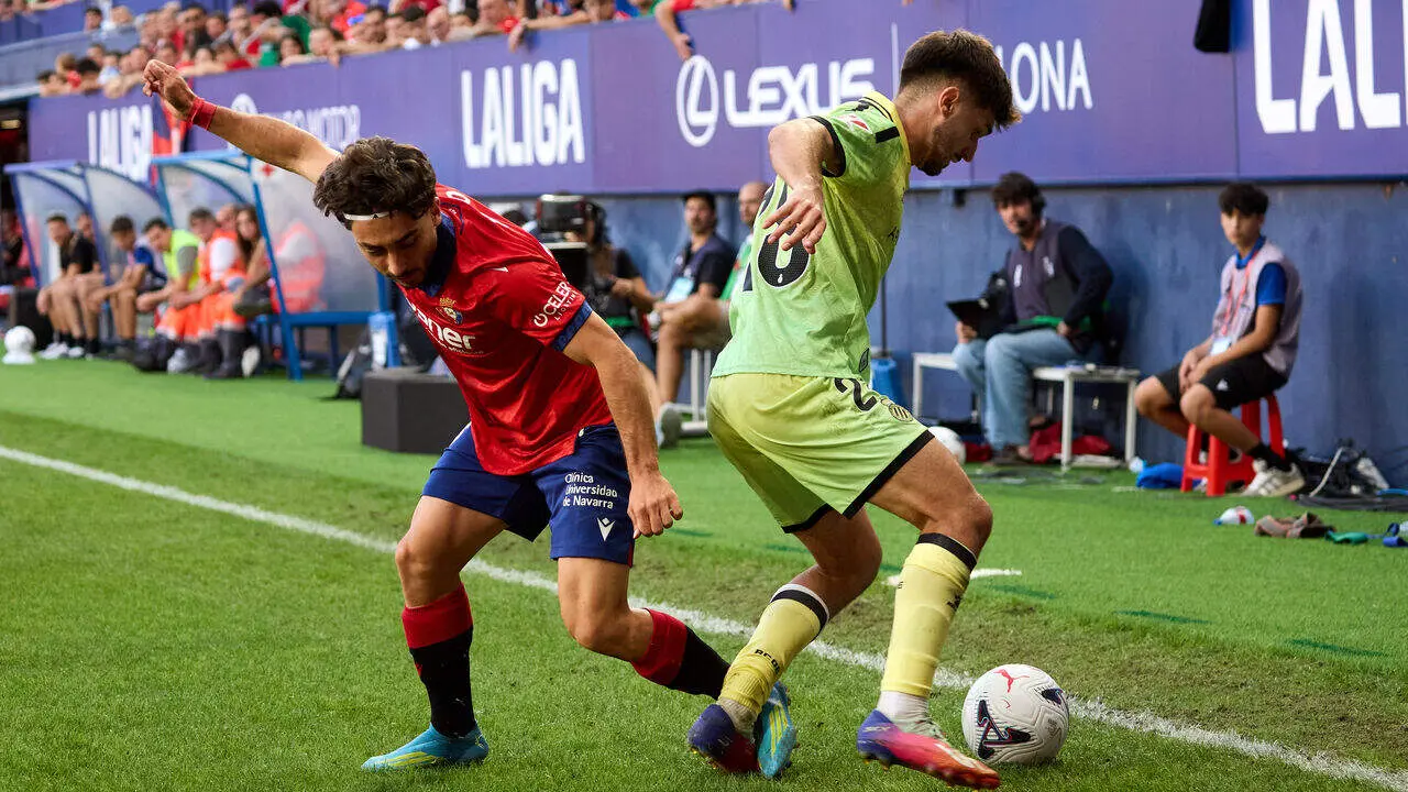 Ra&uacute;l Moro (18. OSA) (Izda) realiza una entrada a Javi Hern&aacute;ndez (28. ESP) (Dcha) durante el partido de LaLiga EA Sports entre CA Osasuna y RCD Espanyol disputado en el estadio de El Sadar en Pamplona. I&Ntilde;IGO ALZUGARAY