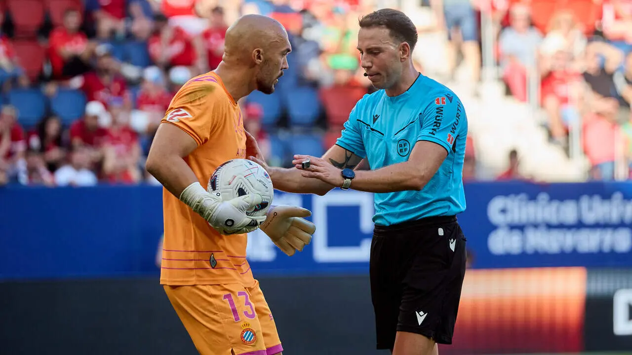 Marko Dmitrovic (13. ESP) (Izda) y Luis Bestard (&Aacute;rbitro) (Dcha) durante el partido de LaLiga EA Sports entre CA Osasuna y RCD Espanyol disputado en el estadio de El Sadar en Pamplona. I&Ntilde;IGO ALZUGARAY