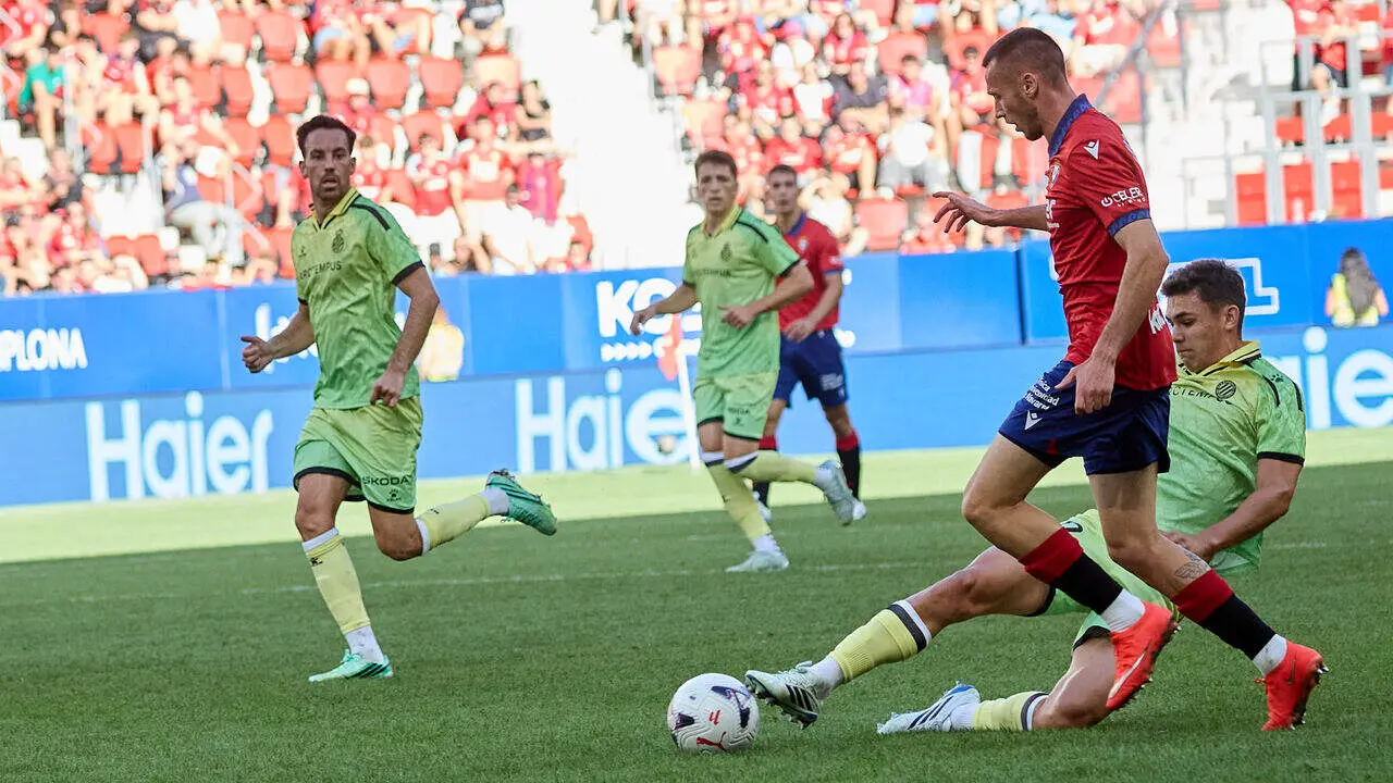 Gabriel Moscardo (20. ESP) (Izda) realiza una entrada a Jonathan Dubasin (21. OSA) (Dcha) durante el partido de LaLiga EA Sports entre CA Osasuna y RCD Espanyol disputado en el estadio de El Sadar en Pamplona. I&Ntilde;IGO ALZUGARAY