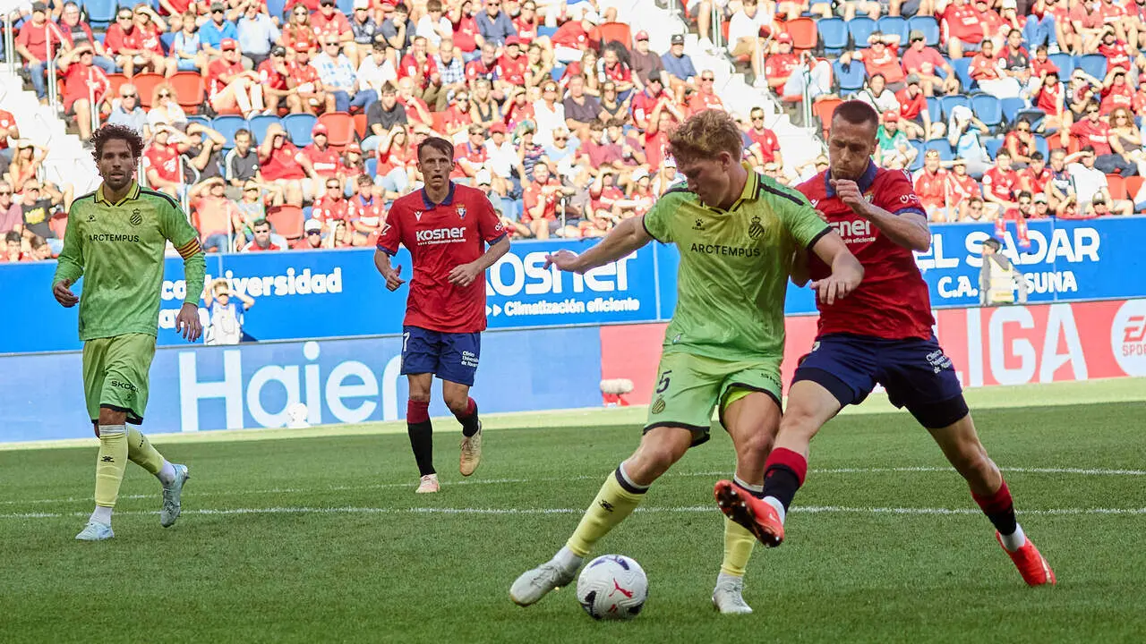 Jonathan Dubasin (21. OSA) (Dcha) realiza una entrada a Clemens Riedel (5. ESP) (Izda) durante el partido de LaLiga EA Sports entre CA Osasuna y RCD Espanyol disputado en el estadio de El Sadar en Pamplona. En la imagen tambi&eacute;n aparecen Leandro Cabrera (6. ESP) (Izda) y Ante Budimir (17. OSA) (Dcha). I&Ntilde;IGO ALZUGARAY