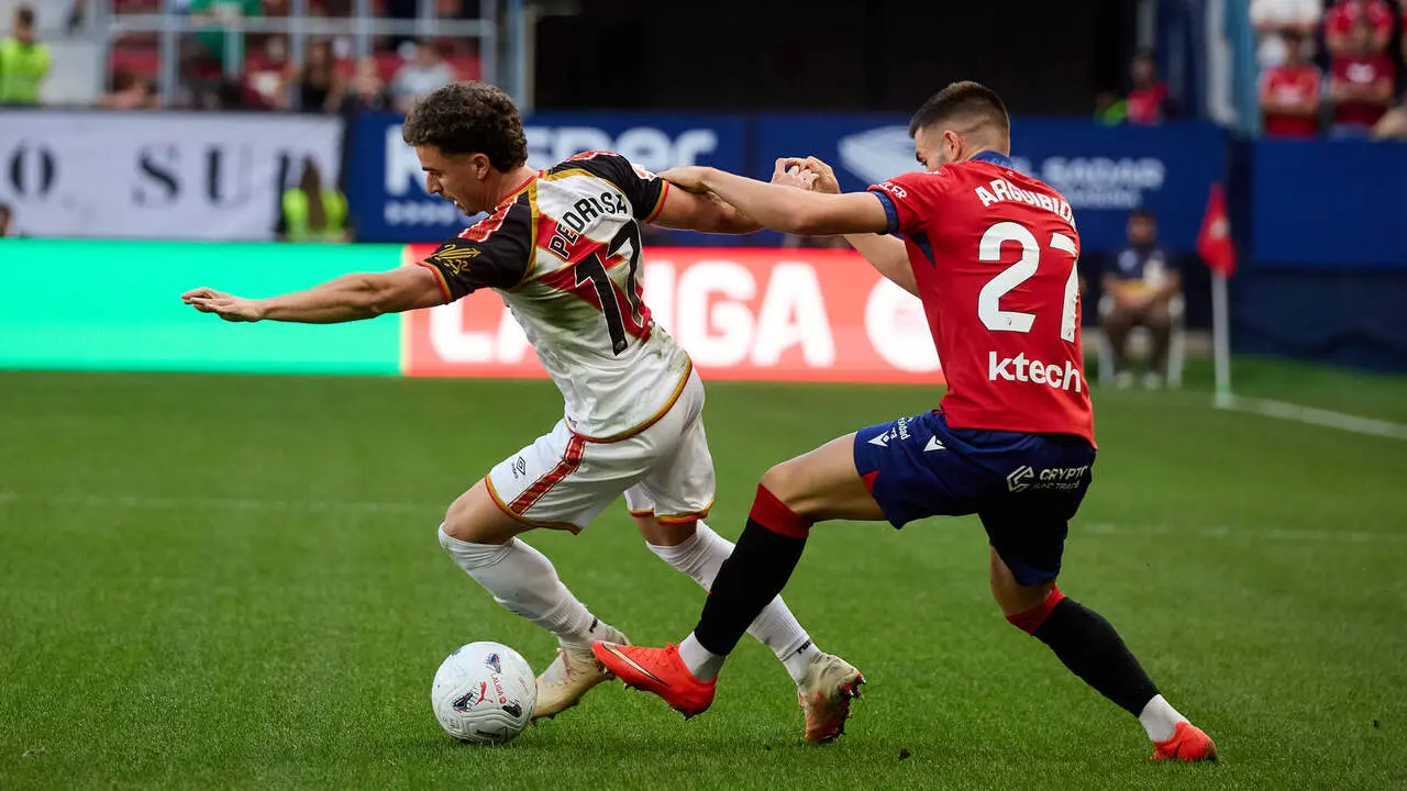 I&ntilde;igo Arguibide (27. OSA) (Dcha) realiza una entrada a Adri&agrave; Pedrosa (17. RAY) (Izda) durante el partido de f&uacute;tbol de LaLiga EA Sports entre CA Osasuna y Rayo Vallecano disputado en el estadio El Sadar de Pamplona I&Ntilde;IGO ALZUGARAY