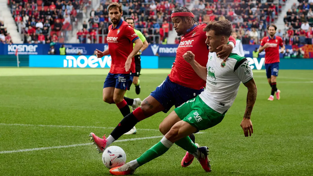 Valentin Rosier (19. OSA) bloquea el disparo de Jorge Salinas (17. RAC) durante el partido de f&uacute;tbol de LaLiga EA Sports entre CA Osasuna y Racing de Santander disputado en el estadio El Sadar de Pamplona I&Ntilde;IGO ALZUGARAY