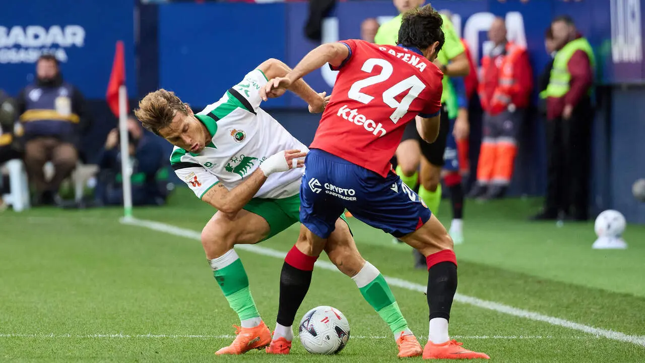 Sergio Canales (20. RAC) y Alejandro Catena (24. OSA) disputan el bal&oacute;n durante el partido de f&uacute;tbol de LaLiga EA Sports entre CA Osasuna y Racing de Santander disputado en el estadio El Sadar de Pamplona I&Ntilde;IGO ALZUGARAY