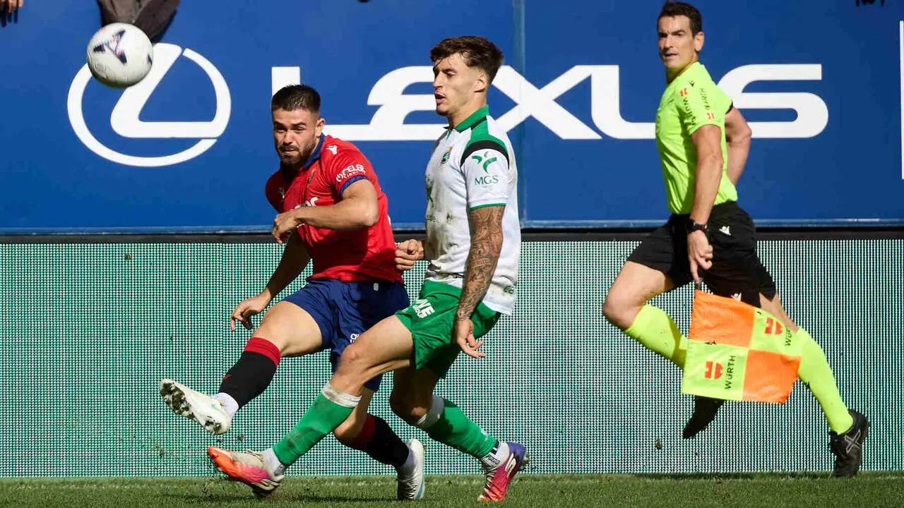 I&ntilde;igo Arguibide (27. OSA) centra el bal&oacute;n ante Jorge Salinas (17. RAC) durante el partido de f&uacute;tbol de LaLiga EA Sports entre CA Osasuna y Racing de Santander disputado en el estadio El Sadar de Pamplona En la imagen tambi&eacute;n aparece Miguel Mart&iacute;nez (&Aacute;rbitro Asistente). I&Ntilde;IGO ALZUGARAY