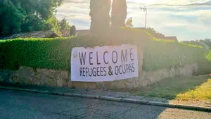 El chalet de Pablo Iglesias amanece con un cartel de bienvenida a los refugiados y okupas