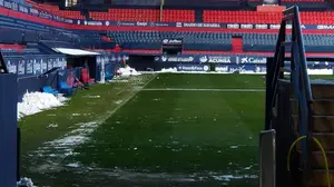Los empleados de mantenimiento de Osasuna retiran la nieve caída sobre el césped del estadio de El Sadar