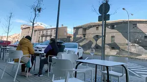 Un joven lanza sillas de una terraza de un bar en Tudela durante el toque de queda