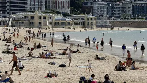 Varios grupos de personas tomando el sol en la playa de La Concha, en San Sebastián. EFE