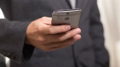 Un hombre mira su teléfono móvil. ARCHIVO