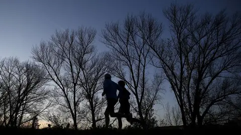 Dos corredores en el paseo del Arga junto a Pamplona, en una jornada con tiempo marcado por los cielos despejados. EFE/Jesús Diges