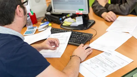 Un funcionario trabaja en la oficina de Hacienda en el primer día de campaña que se puede presentar la declaración de la renta de 2016 de forma presencial. IÑIGO ALZUGARAY