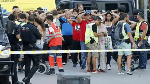 Un grupo de gente con los brazos en alto ante el despliegue policial en las Ramblas tras el brutal atentado de Barcelona EFE