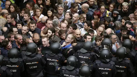 La Policía Nacional trata de evitar que los votantes entre en el colegio electoral. Efe