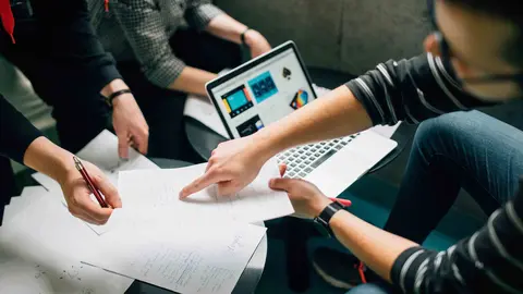 Una grupo de personas trabajan de manera conjunta en un proyecto.