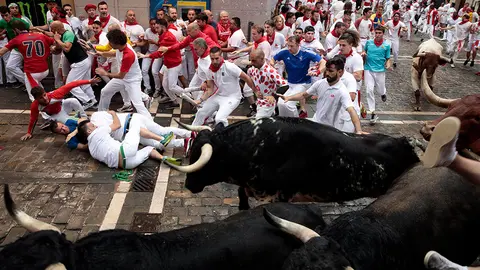 070718-4. Pamplona (Spain), 07/07/2018.- Fighting bulls from the ranch of Puerto de San Lorenzo stampede around a corner in the first 'encierro' or running-with-the-bulls during the Festival of San Fermin 2018 in Pamplona, Spain, 07 July 2018. The festival, locally known as Sanfermines, is held annually from 06 to 14 July in commemoration of the city's patron saint. Hundreds of thousands of visitors from all over the world attend the fiesta. Many of them physically participate in the highlight event - the running of the bulls, or encierro - where they attempt to outrun the bulls along a route through the narrow streets of the old city. (Espa&ntilde;a, Estados Unidos) EFE/EPA/JIM HOLLANDER