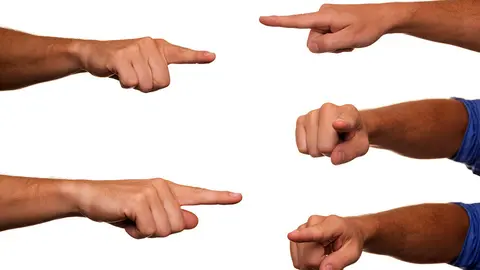 Varias personas se&ntilde;alan al mismo tiempo en distintas direcciones.