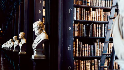 Una biblioteca y estatuas de autores antiguos.