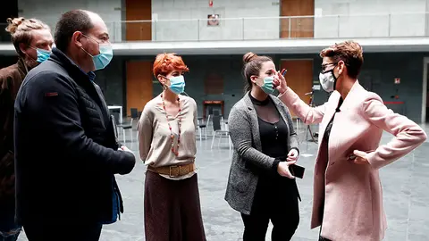 La presidenta del Gobierno foral, María Chivite (d), en el atrio de Parlamento junto al eurodiputado navarro de EH Bildu Pernando Barrena (2i) y a la parlamentaria de la misma formación Bakartxo Ruiz (3d), en un receso del Pleno del Parlamento celebrado este viernes donde se debate sobre la participación y acceso desde Navarra a los fondos europeos aprobados en el Consejo Europeo del 21 de julio de 2020, y los correspondientes proyectos que se propondrán ante el Gobierno español. EFE/ Jesús Diges