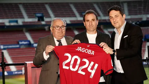 El entrenador de Osasuna, Jagoba Arrasate (c), el presidente del club, Luis Sabalza (i), y el director deportivo, Braulio Vazquez (d), posan con la camiseta del entrenador rojillo despu&eacute;s de firmar esta tarde en el Estadio de El Sadar la renovaci&oacute;n de su contrato por otros dos a&ntilde;os m&aacute;s. EFE/ Jes&uacute;s Diges