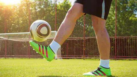 Un adolescente jugando a fútbol en un campo de hierba natural. JAMES RIESS / PIXABAI