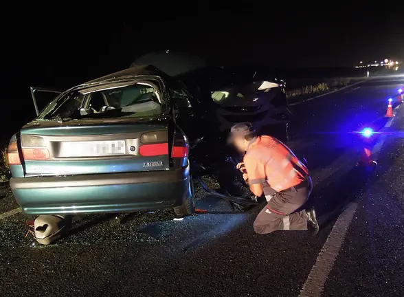 Un policía foral investiga uno de los vehículos accidentados.