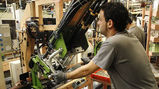 Un operario trabajando en una fábrica de automóviles.