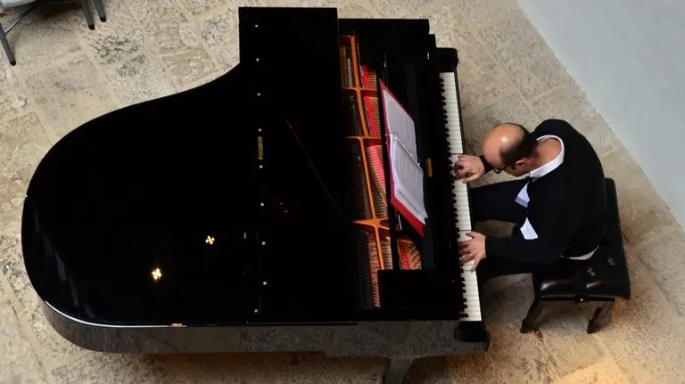 Josu Elberdin, director del concierto solidario, tocando el piano.