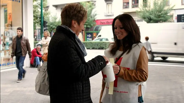 Una mujer entrega un donativo a la voluntaria de la Cruz Roja. /EP