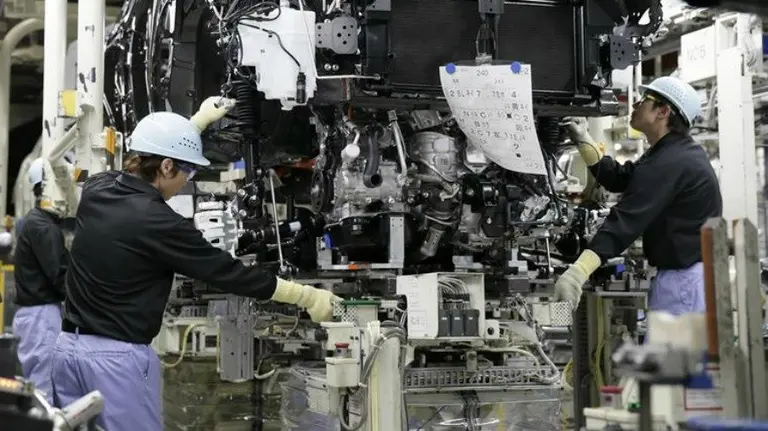 Trabajadores montan un motor.