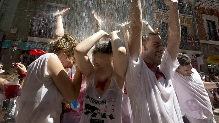 Jóvenes se refrescan con agua que tiran los vecinos desde los balcones (Sanfermines). EFE