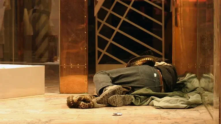 Indigente durmiendo en la calle.