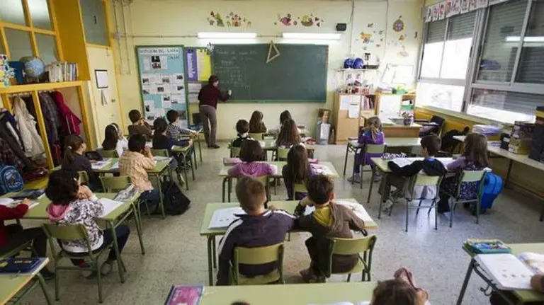 Varios niños atienden a la profesora en una escuela. EFE.