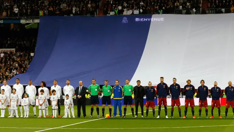 GRA228. MADRID, 21/11/2015.- Los jugadores del Real Madrid y del FC Barcelona se suman a un homenaje a las víctimas de los atentados terroristas del pasado 13 de noviembre en París, con &#39;La Marsellesa&#39; sonando a piano por la megafonía y una bandera de Francia de grandes dimensiones ha ocupado gran parte del lateral, antes del comienzo del partido de la jornada 12º de liga de Primera División que les enfrenta en el Estadio Santiago Bernabéu. EFE/Juanjo Martín