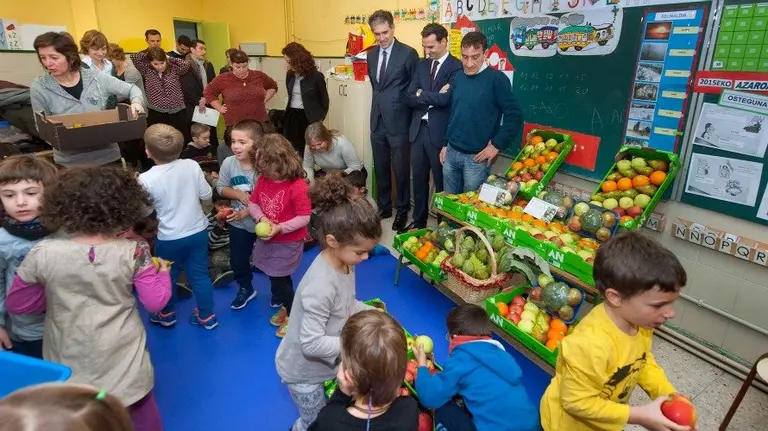 De izda a dcha; Insausti y Larríu, de Caixa Bank, y el director general Gil, con el grupo de niñas y niños.