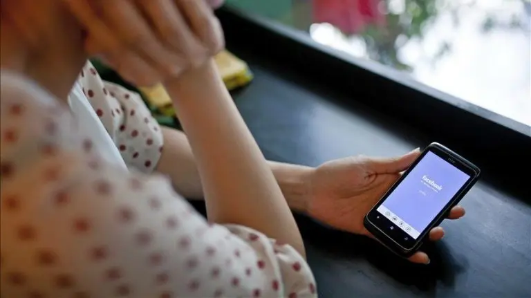 Una mujer se dispone a abrir una página de Facebook desde un teléfono móvil. EFE.
