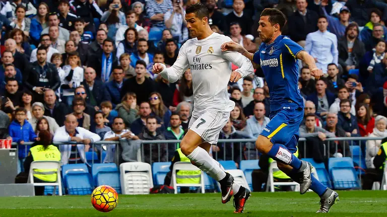GRA181. MADRID, 05/12/2015.- El delantero portugués del Real Madrid, Cristiano Ronaldo (i), en la jugada del cuarto gol de su equipo ante el Getafe, durante el partido de la decimocuarta jornada de liga en Primera División que se disputa esta tarde en el estadio Santiago Bernabéu. EFE/J.P.GANDUL