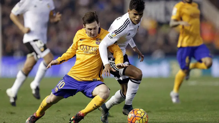 Messi (Barcelona) en pugna con un contrario en Mestalla.