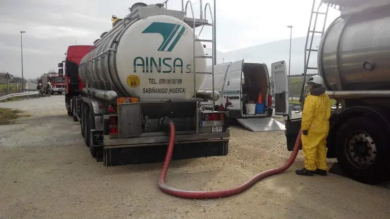 Trasvase de la carga que transportaba el cami&oacute;n accidentado (a la derecha).