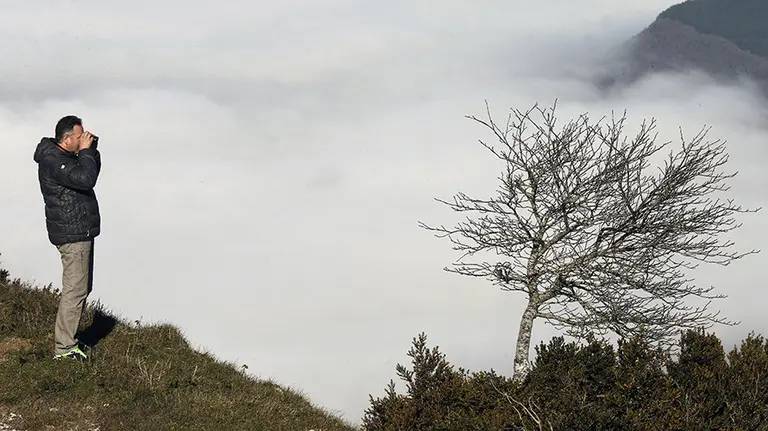 Una persona en el alto de la Higa de Monreal donde la niebla que cubre gran parte de la comunidad foral desde primeras horas de la mañana es la nota meteorológica más común en estas últimas jornadas. La temperatura y sobre todo la ausencia de precipitaciones sigue siendo inusual en estas fechas del año. EFE/Jesús Diges
