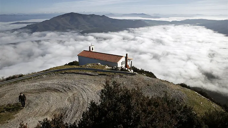 Una persona camina por el alto de la Higa de Monreal donde la niebla que cubre gran parte de la comunidad foral desde primeras horas de la mañana es la nota meteorológica mas común en estas últimas jornadas. La temperatura y sobre todo la ausencia de precipitaciones sigue siendo inusual en estas fechas del año. EFE/Jesús Diges