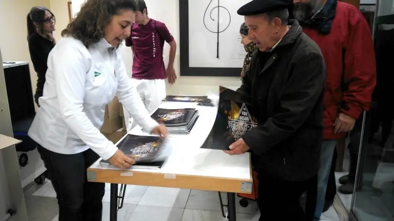 Un vecino de Pamplona recogiendo el calendario municipal de 2016.