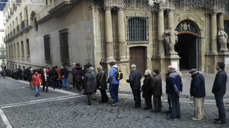 Vecinos de Pamplona haciendo cola para recoger el calendario municipal de 2016.