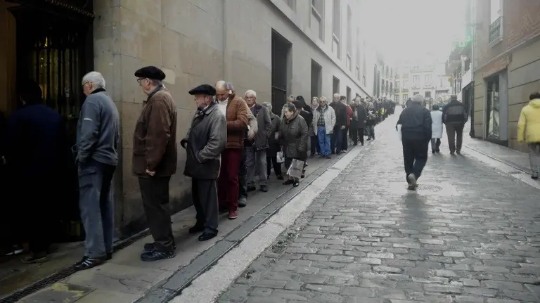 Vecinos de Pamplona haciendo cola para recoger el calendario municipal de 2016
